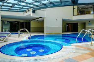a large swimming pool in a building with a large tub at Chic 1BR Next to Dubai Marina Promenade by Livbnb in Dubai