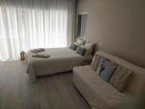 a hotel room with a bed and a couch at Impervila 201 in Vilamoura