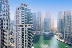 Chic 1BR Next to Dubai Marina Promenade by Livbnb في دبي: اطلالة على نهر في مدينة ذات مباني طويلة