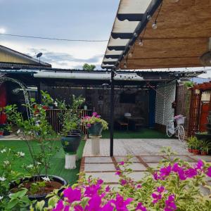een patio met een bos planten en bloemen bij Cheqma Tiny Chalet in Kota Bharu