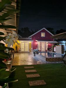 a house at night with a pool in front of it at Cheqma Tiny Chalet in Kota Bharu