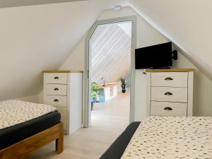 Schlafzimmer im Dachgeschoss mit 2 Betten und einem Spiegel in der Unterkunft Lüttjet Huus in Lügde