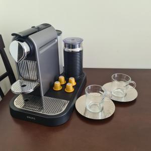 a coffee maker sitting on a table with two glasses at Christina´s Beachside Apartment in Rio