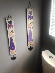 a bathroom with three ties on a wall next to a toilet at Pecan Tree Parys in Parys