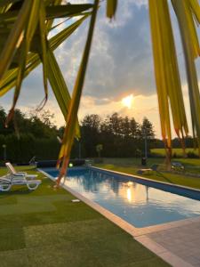 una piscina con puesta de sol en el fondo en Les gîtes du Valjoly 1, en Touvent