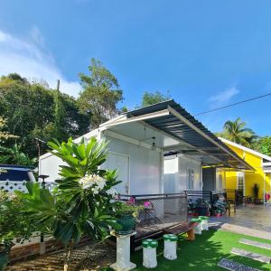 ein kleines Haus mit einer Terrasse und Pflanzen in der Unterkunft Cheqma Tiny Chalet in Kota Bharu