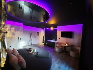 Nuits Blanches في لييج: غرفة معيشة مع أضواء أرجوانية على الحائط