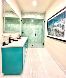a bathroom with a sink and a glass shower at AZUL on Avenida Del Mar (1/2 Mile to the PIER!) in San Clemente