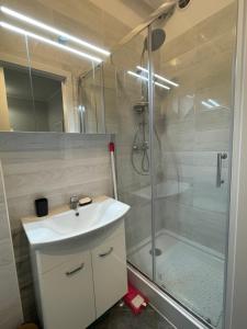 La salle de bains est pourvue d'un lavabo et d'une douche. dans l'établissement Home3city Przytulny, à Sopot