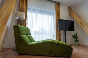 - Silla verde en la sala de estar con TV en Fabrica Apartments 14 en Cluj-Napoca