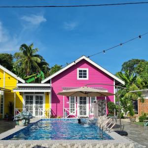 a pink house with a swimming pool in front of it at Cheqma Tiny Chalet in Kota Bharu