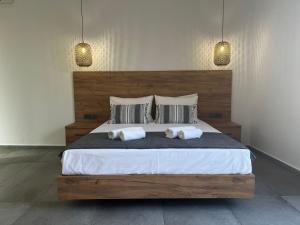 a bedroom with a large bed with two pillows at Sydney Hotel in Kefalos