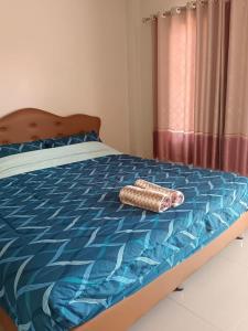 a bedroom with a bed with a blue comforter at JUNPEN RESORT in Ban Hai Yong
