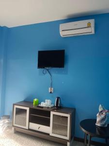 un soggiorno con TV e parete blu di JUNPEN RESORT a Ban Hai Yong