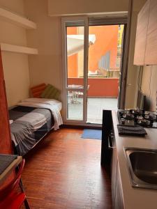 um quarto com uma cama e uma cozinha com uma varanda em Scendi dal treno em Bolonha