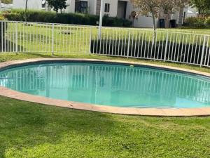 una piscina en un patio con una valla en Executive Modern Apartment, en Fourways