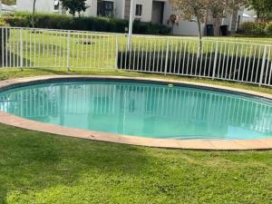 a swimming pool in a yard with a fence at Executive Modern Apartment in Fourways