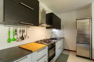 uma cozinha com electrodomésticos de aço inoxidável e armários pretos em La terrazza di Giulietta em San Giovanni Lupatoto