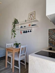 a kitchen with a table and two chairs and a table at Camere A Oriente II in Torre dell'Orso