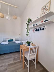 een woonkamer met een tafel en een bed bij Camere A Oriente II in Torre dell'Orso