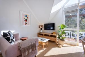 a living room with a couch and a tv at Rozendal Stay in Stellenbosch