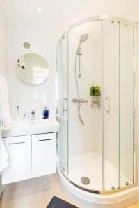 a white bathroom with a shower and a sink at Garden Apartment in Listed Building in Leamington Spa