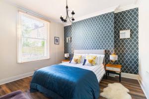 a bedroom with a bed with a blue blanket at Garden Apartment in Listed Building in Leamington Spa