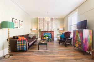 a living room with two couches and a fireplace at Garden Apartment in Listed Building in Leamington Spa
