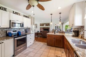a kitchen with white cabinets and a ceiling fan at Lake Escape Lakefront Lodge at Red Bud Cove in Hollister