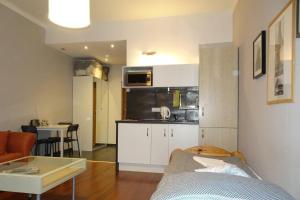 a small apartment with a kitchen and a living room at Cybulskiego Guest Rooms in Kraków