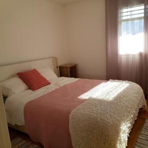 a bedroom with a bed with a red pillow and a window at 2 bedrooms appartement with lake view enclosed garden and wifi at Pont en Ogoz in Avry devant Pont