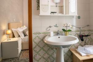 een badkamer met een witte wastafel en een bed bij Baldassini Suites in Rome +37 foto's
