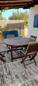 a wooden picnic table and a chair on a deck at Paradise, Porto Saler ET7104 in La Savina