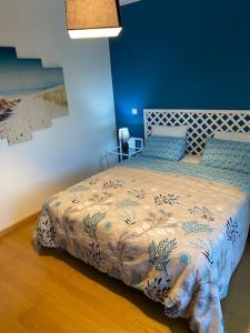a bed in a bedroom with a blue wall at Villa avec piscine dans un golf in Palmela