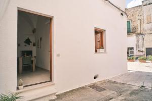 a white house with a window and a table at Casa FraLu in Miggiano