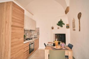 una cucina con tavolo in legno e una sala da pranzo di Casa FraLu a Miggiano