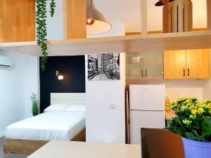 a small room with a bed and a refrigerator at Hantke28 Budget Apartment in Haifa