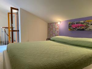 a bedroom with two beds and a purple wall at CASA VACANZA DAMAR in Mascali