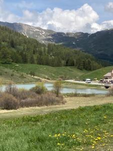 a river in a field with mountains in the background at Le Chalet d’Andrea in Vars