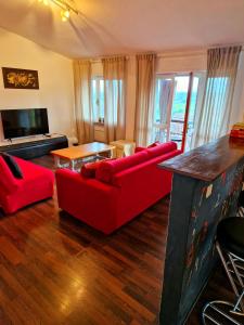 ein Wohnzimmer mit einem roten Sofa und einem Tisch in der Unterkunft Casa nostra in Cisterna dʼAsti