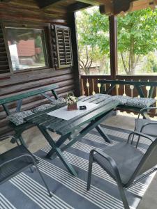 einen grünen Picknicktisch und Stühle auf einer Veranda in der Unterkunft Brvnara Nenadić in Užice
