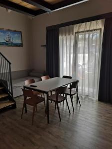 una sala da pranzo con tavolo e sedie in una stanza di Suite Apartments a Cervia