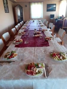 uma mesa longa com pratos de comida em Pensiunea Iza em Bradu