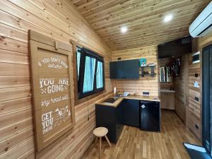 a kitchen in a tiny house with wooden walls at Cãsuța de sub nuc in Piatra Neamţ