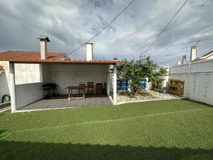 een patio met een tafel en een groen gazon bij Casa na Vila by Trip2Portugal in Figueiró dos Vinhos