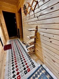 a room with a wooden wall and a checkerboard floor at Trabzon Mountain House-UZUNLU in Trabzon