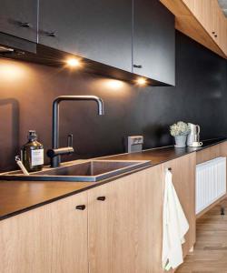 a kitchen with a sink and a black wall at The View in Copenhagen