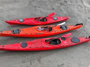three red kayaks are sitting on the ground at Holiday home averøy III in Averoy