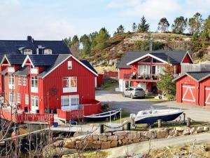um grupo de casas vermelhas com um barco num parque de estacionamento em Holiday home averøy III em Averoy