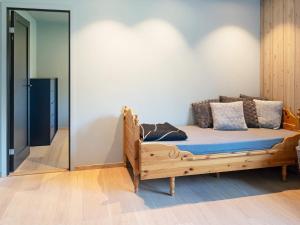 1 dormitorio con cama de madera y almohadas en Holiday home INDERØY, 